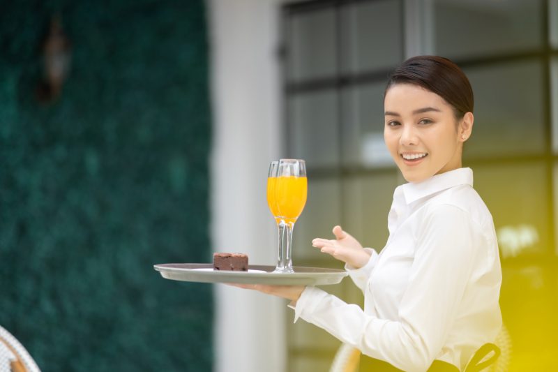 飲み物を持っている外国人女性の店員